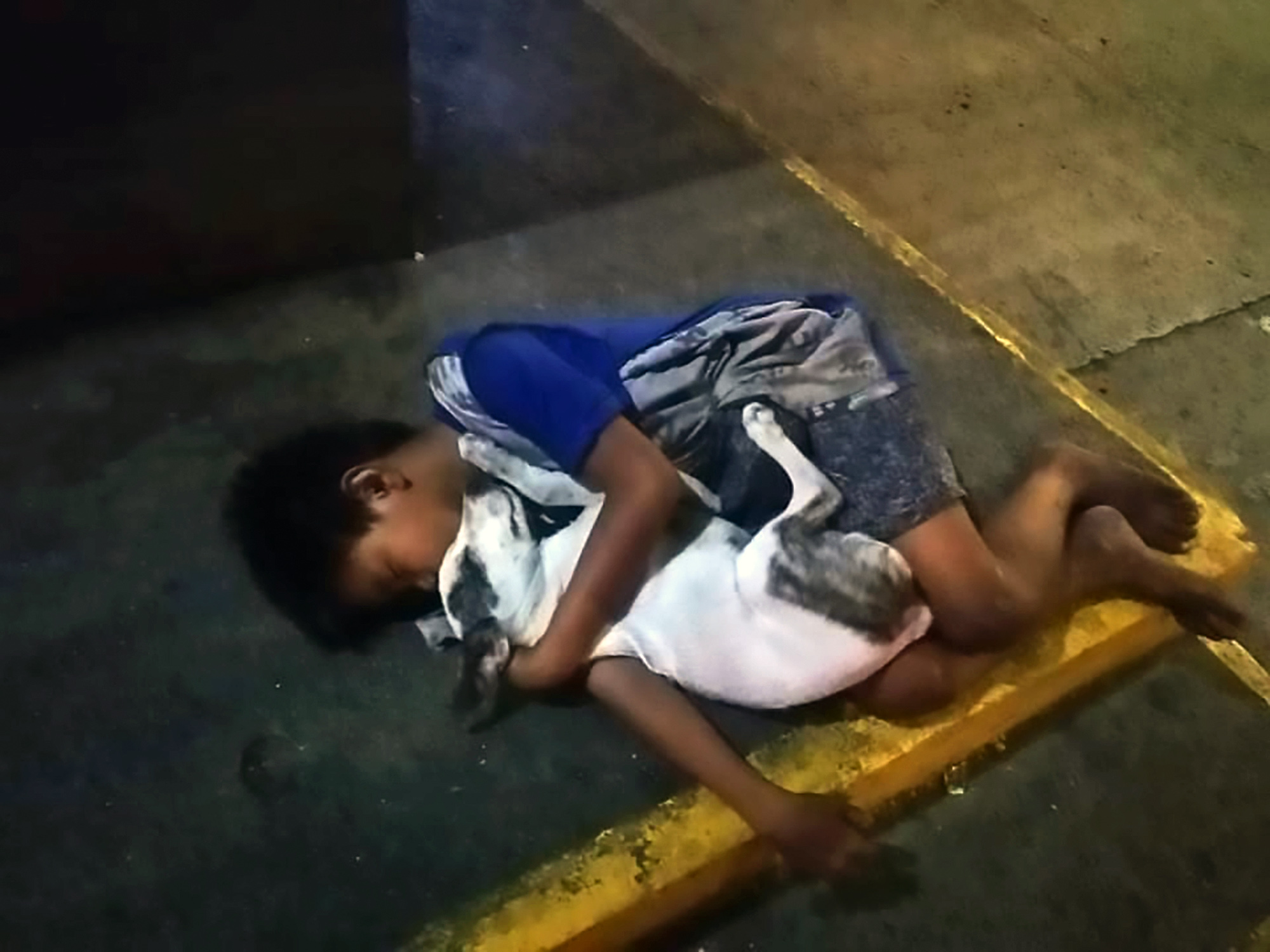 Read more about the article Homeless Boy Clutches Pet Dog While Sleeping On Pavement