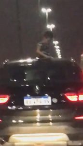 Read more about the article Moment Boy Stands In BMW Sunroof At Night On Motorway
