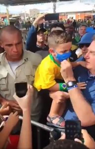 Read more about the article Moment Brazil President Lowers Boys Face Mask To Pose For Snaps