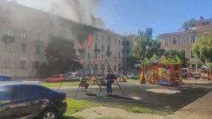 Read more about the article Children Playing On Swings As Fire Rages Yards Away Compared With Disaster Girl Meme