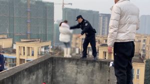 Read more about the article Moment Cop Risks Life To Push Young Woman Off Ledge And Into Firefighters Arms
