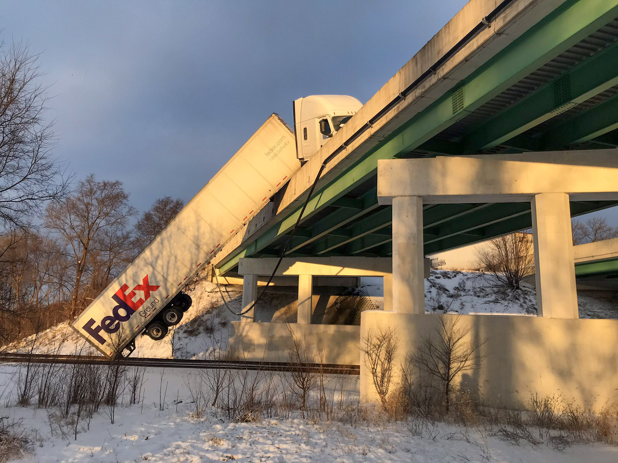 Read more about the article Crashed FedEx Lorry Dangles From Overpass And Blocks Active Railway In Indiana